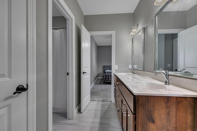 full bathroom featuring baseboards, a sink, marble finish floor, and double vanity