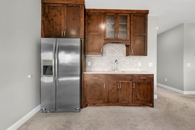 kitchen with baseboards, light carpet, a sink, and stainless steel fridge with ice dispenser