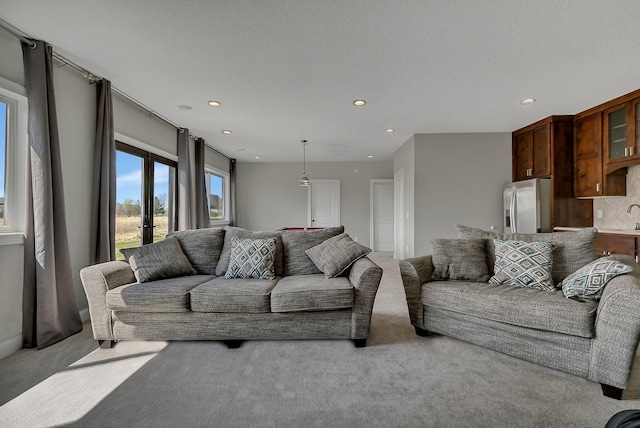 living area featuring recessed lighting and light carpet