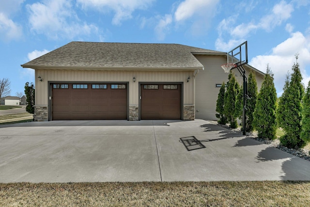 view of property exterior featuring a garage, stone siding, roof with shingles, board and batten siding, and concrete driveway