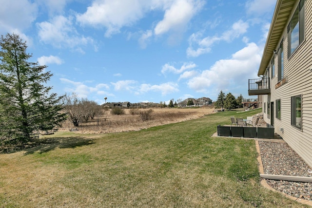 view of yard featuring a patio and a balcony