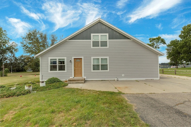 bungalow-style home with board and batten siding and a front lawn