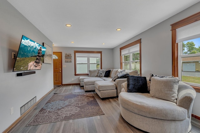 living area with recessed lighting, wood finished floors, visible vents, and baseboards