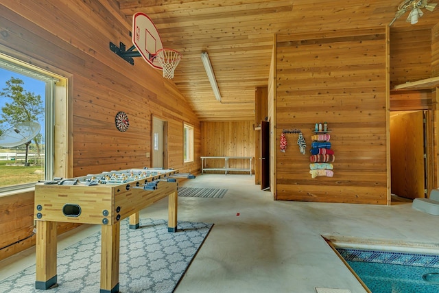 recreation room with lofted ceiling, wood walls, and carpet floors