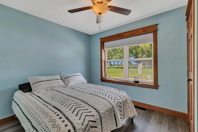 bedroom with wood finished floors, baseboards, and a ceiling fan