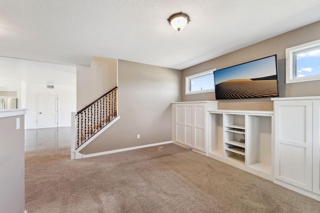 2724 Neal Ave N, West Lakeland Twp, MN 55082 - unfurnished living room with carpet flooring, stairs, baseboards, and a textured ceiling