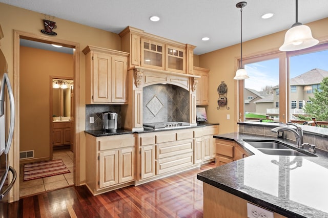 2469 Tournament Players Cir S, Blaine, MN 55449 - kitchen with visible vents, decorative backsplash, light brown cabinetry, a sink, and cooktop