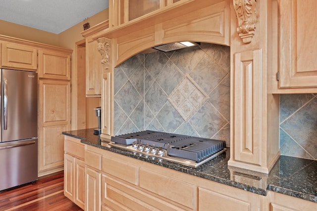 2469 Tournament Players Cir S, Blaine, MN 55449 - kitchen with appliances with stainless steel finishes, light brown cabinets, dark stone countertops, decorative backsplash, and dark wood-style floors