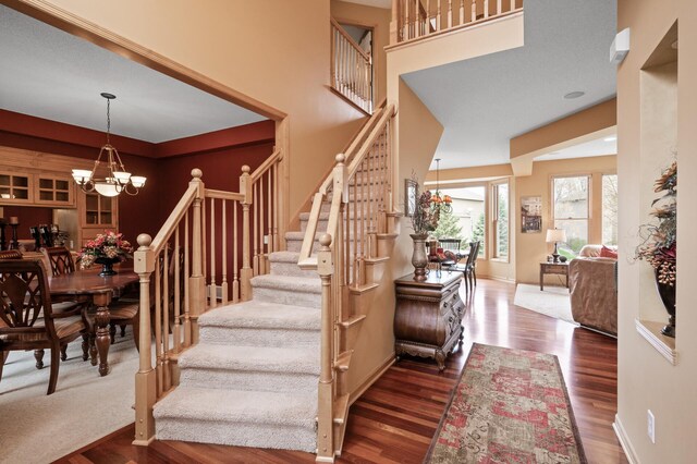 2469 Tournament Players Cir S, Blaine, MN 55449 - stairs with baseboards, a chandelier, and wood finished floors