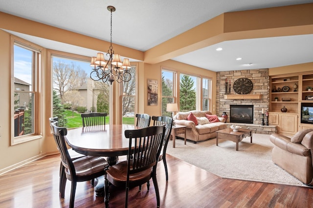 2469 Tournament Players Cir S, Blaine, MN 55449 - dining room with baseboards, wood finished floors, a notable chandelier, and a fireplace
