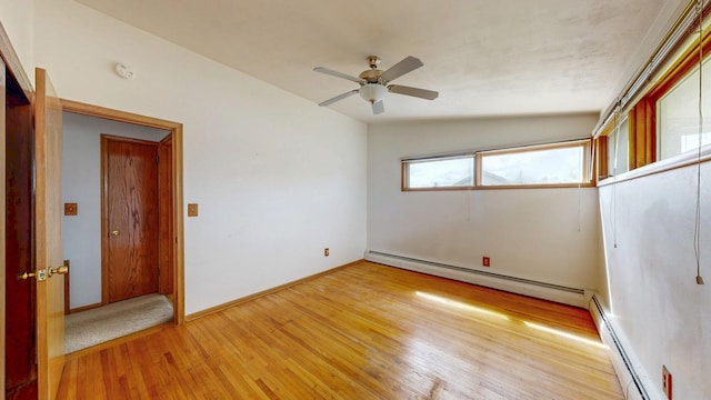 empty room with a baseboard heating unit, light wood-style flooring, ceiling fan, and a smoke detector