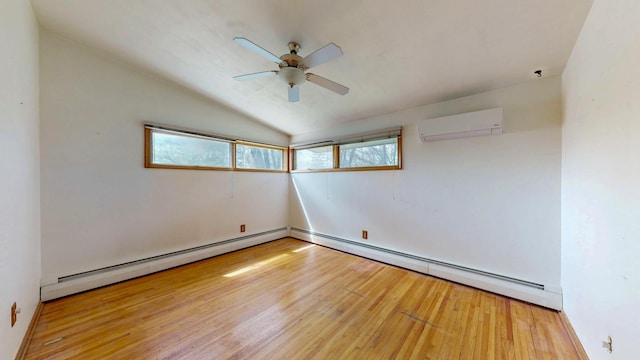 spare room featuring an AC wall unit, wood finished floors, a ceiling fan, a baseboard radiator, and vaulted ceiling