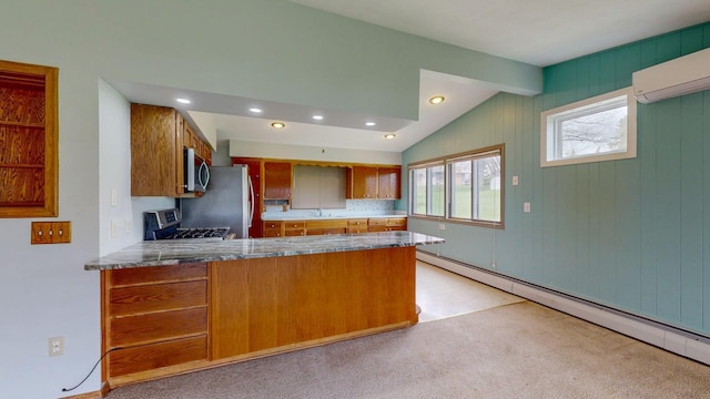 kitchen with appliances with stainless steel finishes, brown cabinetry, a sink, a peninsula, and baseboard heating