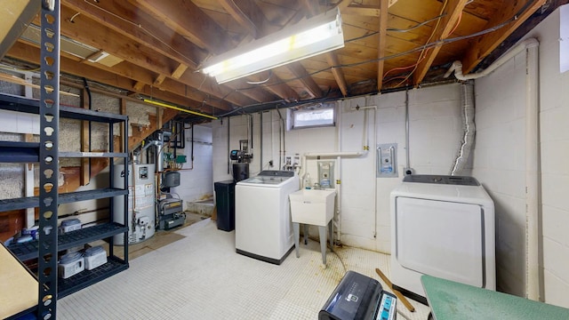 basement featuring washing machine and dryer, water heater, and a sink