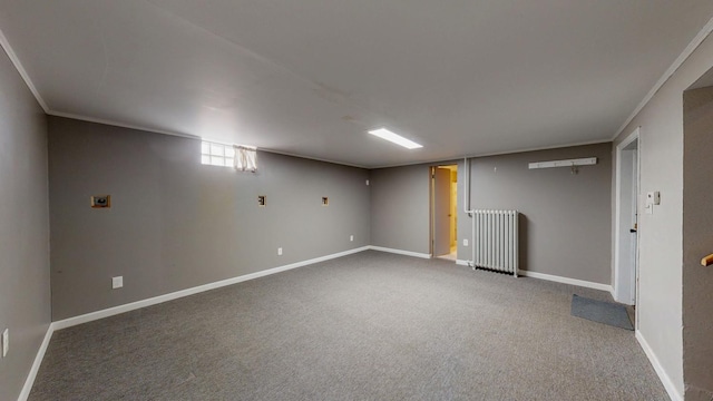 below grade area featuring radiator, carpet, baseboards, and ornamental molding