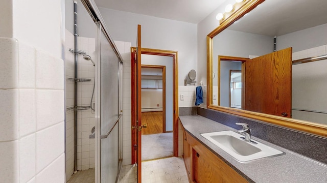 full bathroom featuring baseboard heating, a stall shower, vanity, and tile patterned floors