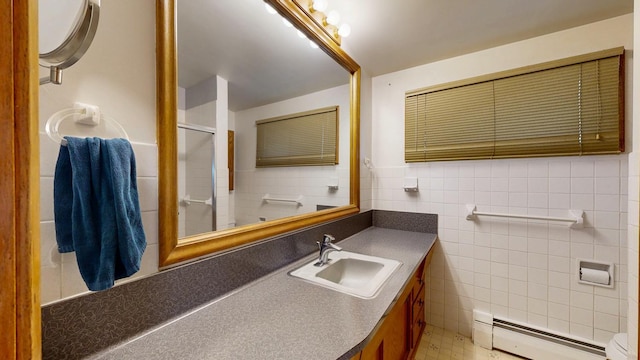 bathroom with a baseboard radiator, tile walls, a shower with door, vanity, and toilet