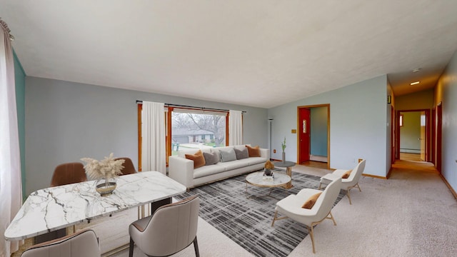 living area featuring baseboard heating, light carpet, vaulted ceiling, and baseboards