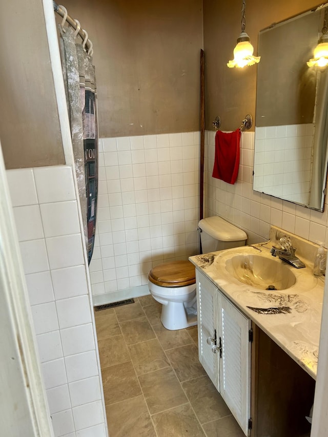 full bathroom featuring tile walls, visible vents, toilet, and vanity