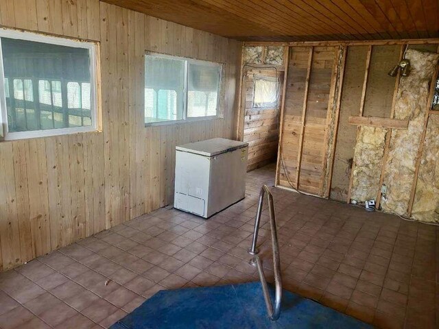 laundry room featuring wooden ceiling, wood walls, and tile patterned flooring