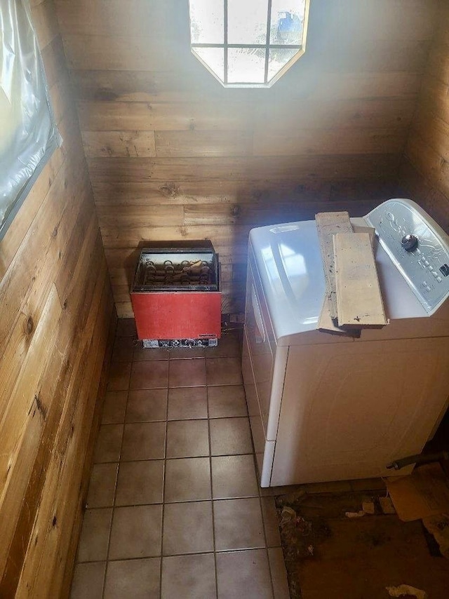 interior space with washing machine and dryer, wood walls, tile patterned floors, and laundry area