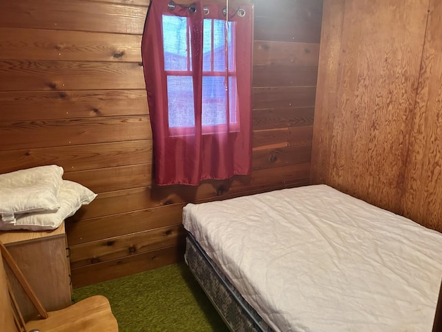 carpeted bedroom featuring wooden walls