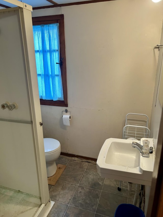 bathroom with tile patterned floors, toilet, and a sink