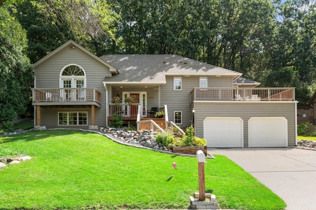 split foyer home featuring a balcony, a deck, a front yard, roof with shingles, and concrete driveway