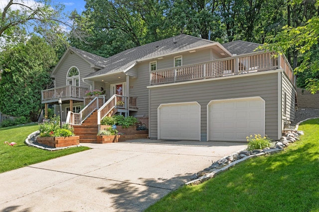 bi-level home featuring a shingled roof, an attached garage, a front yard, a balcony, and driveway