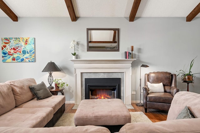 living room with wood finished floors, beam ceiling, and a premium fireplace