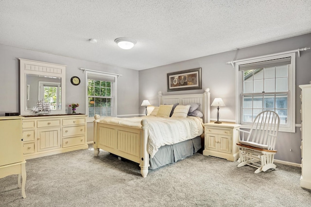 bedroom featuring a textured ceiling, light carpet, and baseboards