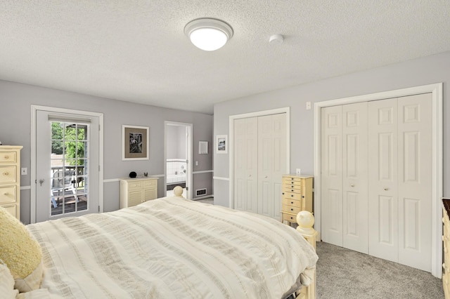 carpeted bedroom with multiple closets, access to outside, and a textured ceiling