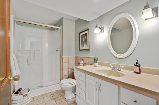 bathroom with tile patterned flooring, vanity, toilet, tile walls, and a shower stall