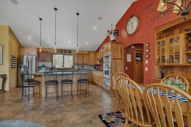 26182 Jericho Rd, Saint Joseph Twp, MN 56301 - kitchen with a warming drawer, stainless steel appliances, arched walkways, tasteful backsplash, and a kitchen island