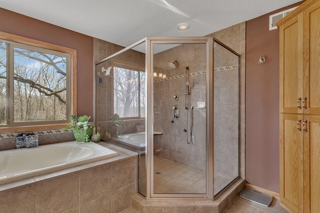 26182 Jericho Rd, Saint Joseph Twp, MN 56301 - bathroom featuring a bath, healthy amount of natural light, a shower stall, a textured ceiling, and tile patterned flooring