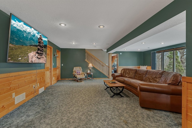 26182 Jericho Rd, Saint Joseph Twp, MN 56301 - carpeted living room with recessed lighting, stairs, wood walls, and a wainscoted wall