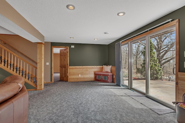 26182 Jericho Rd, Saint Joseph Twp, MN 56301 - living room with carpet flooring, a textured ceiling, wood walls, recessed lighting, and a wainscoted wall
