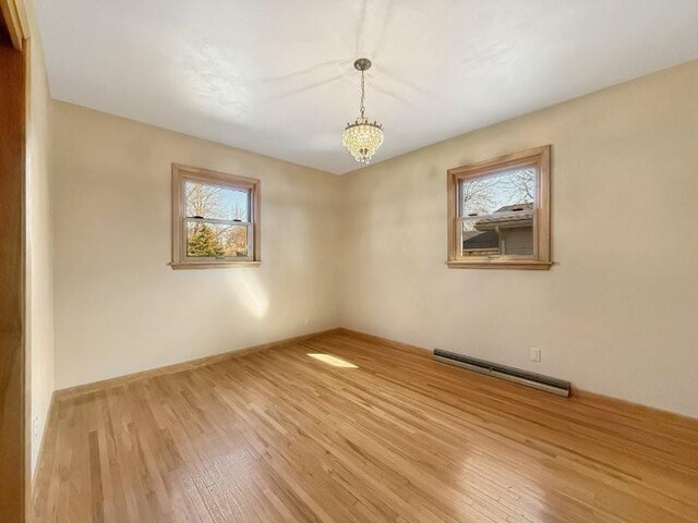1254 State St, Fairmont, MN 56031 - spare room featuring a baseboard heating unit, light wood-style floors, and a healthy amount of sunlight
