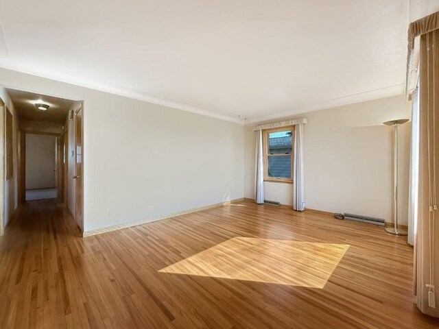 1254 State St, Fairmont, MN 56031 - spare room with baseboards, wood finished floors, and crown molding