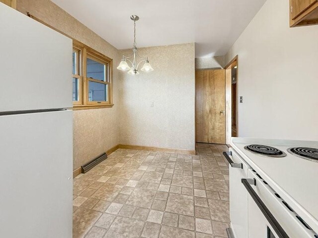 1254 State St, Fairmont, MN 56031 - kitchen with baseboards, an inviting chandelier, white appliances, pendant lighting, and light countertops
