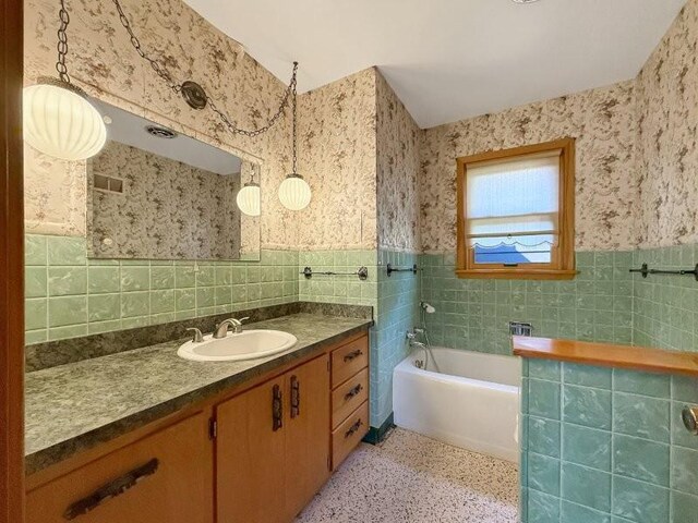 1254 State St, Fairmont, MN 56031 - bathroom featuring tile walls, a garden tub, vanity, and wainscoting