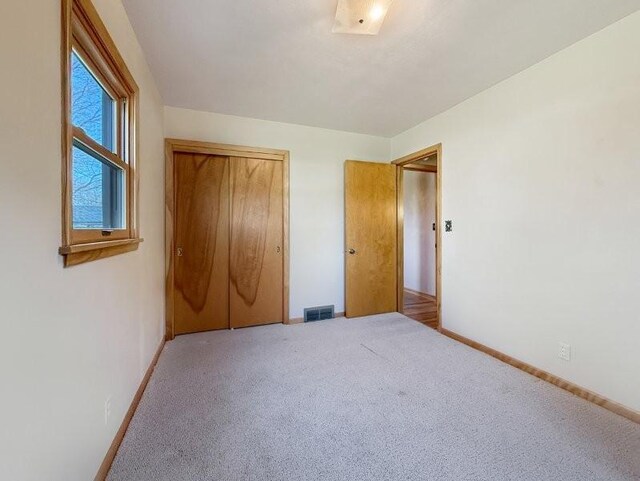 1254 State St, Fairmont, MN 56031 - unfurnished bedroom with baseboards, carpet flooring, and visible vents