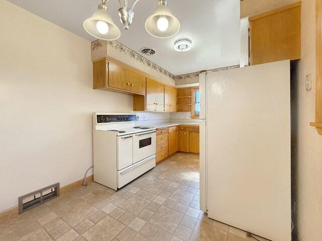 1254 State St, Fairmont, MN 56031 - kitchen with stone finish flooring, visible vents, white appliances, and light countertops