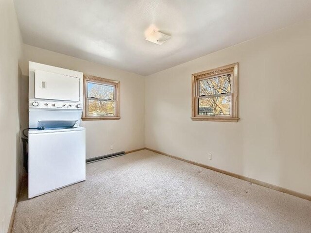 1254 State St, Fairmont, MN 56031 - laundry room featuring a baseboard radiator, carpet floors, baseboards, stacked washer and clothes dryer, and laundry area