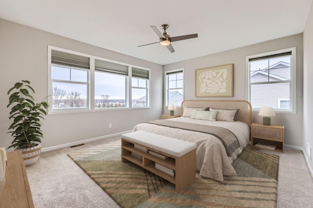 carpeted bedroom with baseboards, ceiling fan, and visible vents