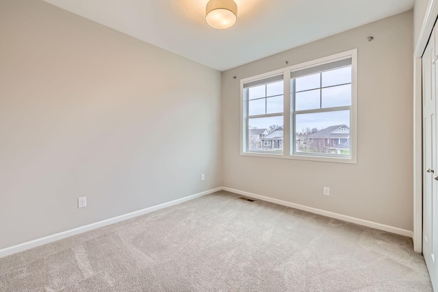 carpeted spare room with baseboards and visible vents