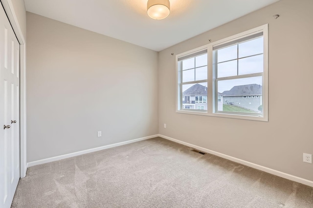 unfurnished bedroom featuring baseboards, visible vents, carpet, and a closet