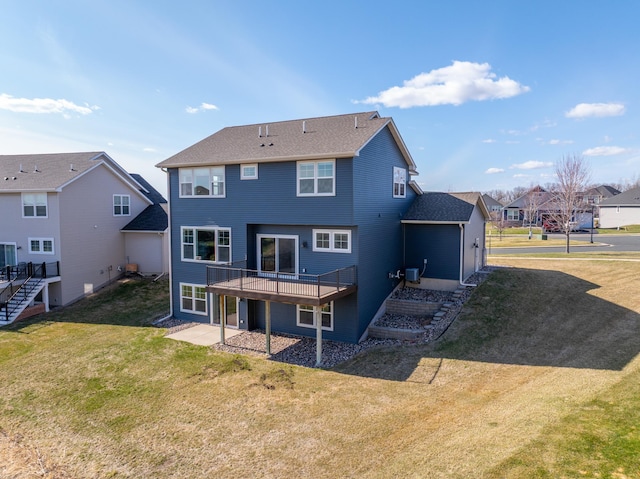 back of house featuring a residential view, a lawn, a deck, and cooling unit