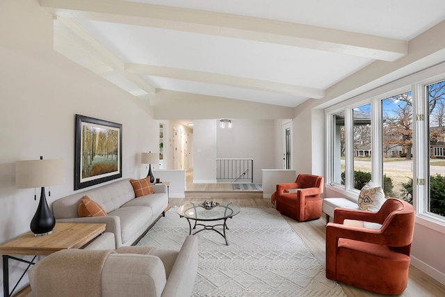 living area with vaulted ceiling with beams, baseboards, and light wood-style flooring