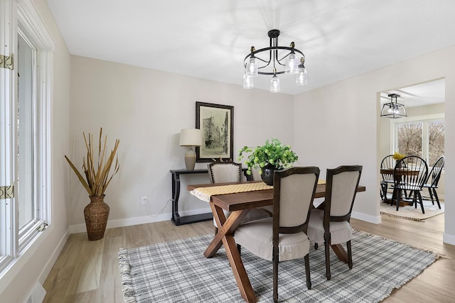 dining room featuring a chandelier, wood finished floors, visible vents, and baseboards